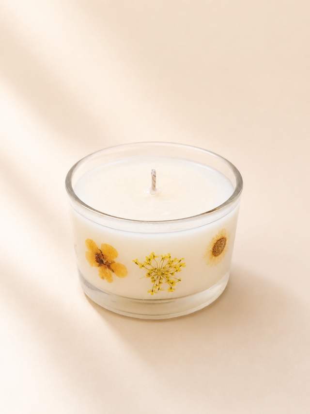 Candle with pressed flowers set in the wax